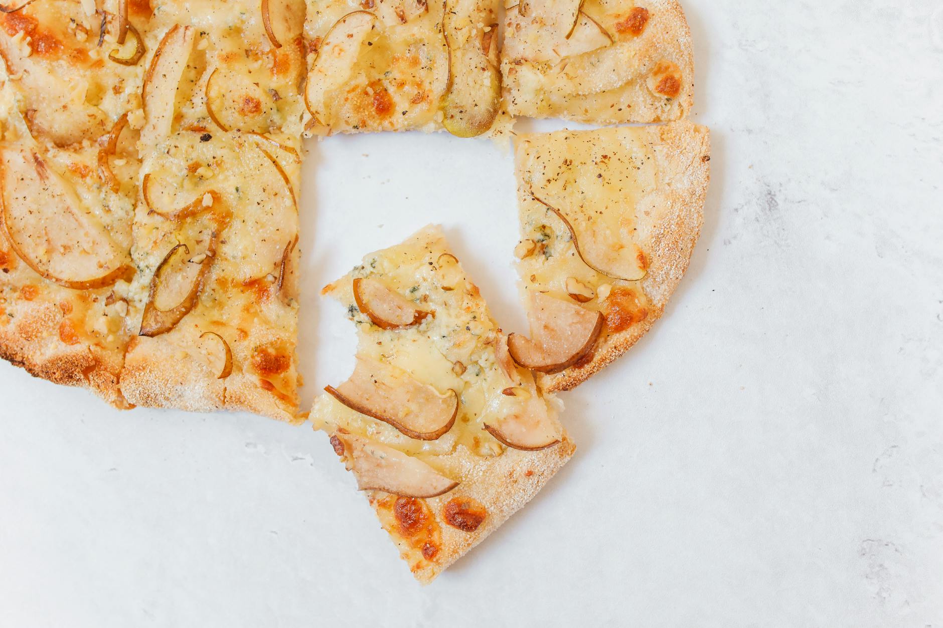 Pizza bianca z gruszką i gorgonzolą na białym tle